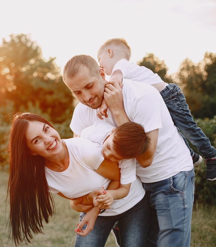 Family with cute little child. Father in a white t- shirt. Sunset background.